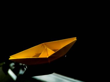 Origami kağıt teknesi suda yüzüyor.