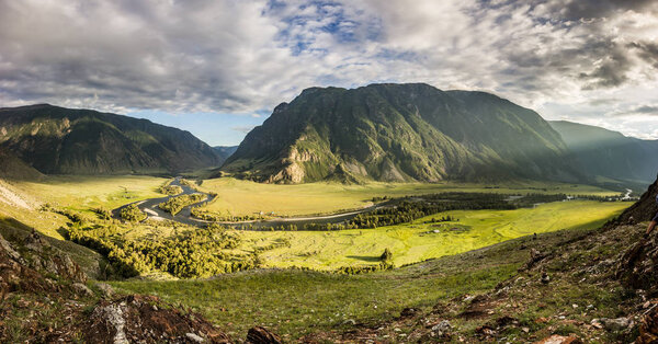 Panoramic evening view of Chulyshman valley with sun and clouds