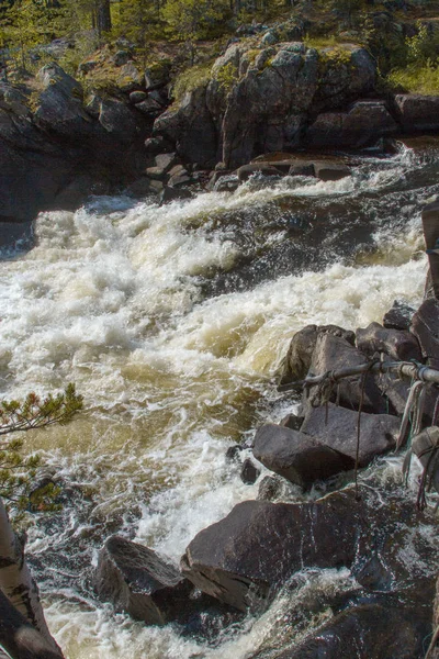 stormy forest river among the stone banks