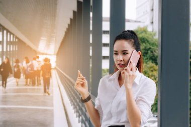 Akıllı telefon tutarak ve müşteriyle konuşurken iş kadınları.