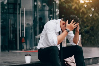 Asya genç işadamı stres önünde elleriyle kafasını kapsayan ofis oturma.