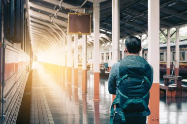 Asya adam ayakta bekleyen ve gelecekteki kavramı seyir platformu tren istasyonunda.
