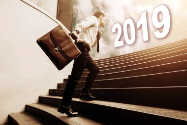 Evrak Çantası'nı tutarak ve merdivenler üzerinde yürümek ve gelecekteki 2019 newyear kavramı için arıyor işadamı.