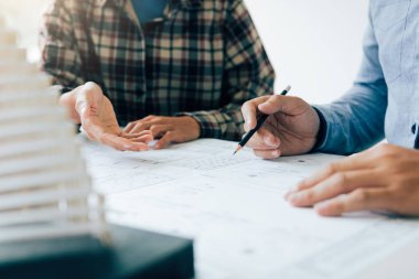 İnsanlar ev satın almak için plan detay gösterilen yatırımcı adam.