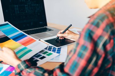 Dijital grafik tablet kullanarak ve modern ev ofis kalemiyle çizim masası üzerinde serbest yaratıcı tasarımcı.