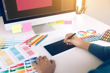 Dijital grafik tablet kullanarak ve modern ev ofis kalemiyle çizim masası üzerinde serbest yaratıcı tasarımcı.