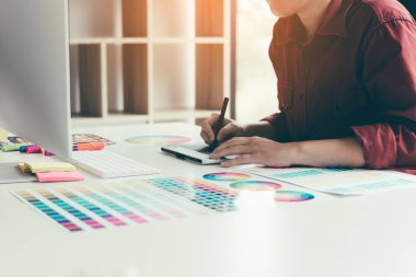 Retoucher dizüstü bilgisayar ve dijital grafik tablet kullanarak office odasında çalışma.