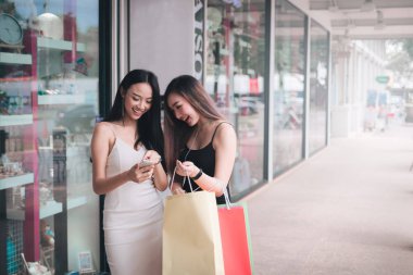 Alışveriş merkezinde Smartphone kullanan iki beatyful kadın.