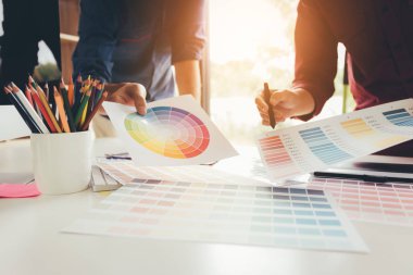 Masasında çalışan grafik tasarımcı ve renk birlikte seçimi.