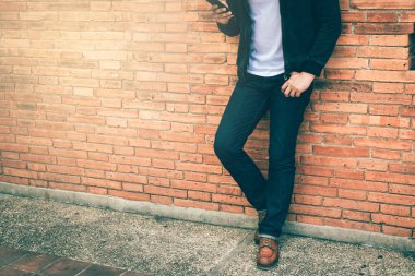 Akıllı bir adam ayakta açık bir duvar arka plan.