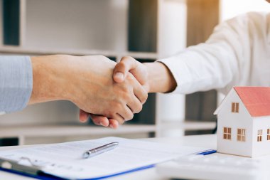 Ev ofis bir sözleşme imzaladıktan sonra müşteri ve Emlak broker elini sıkarken yakın çekim.