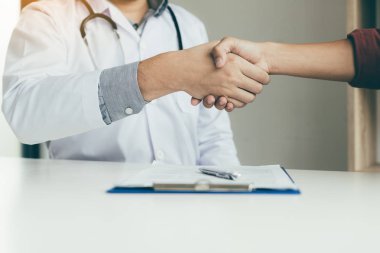 Ofiste büyük hasta elini sıkarken doktor.