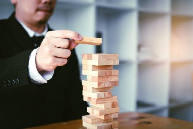 Strateji kavramı ve planlama ile ahşap blok yığınları oyun oynarken işadamı el.