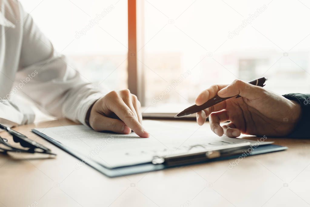 Business advisor financial man pointing on contract paper to customer reading contract.