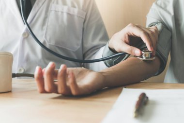 Doktor stetoskop kullanarak yakından almak hastanın kol mekândaki oda ofis.