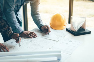 İki mühendislik adam ya da bir proje üzerinde çalışıyor ve bakarak ile birlikte tartışmaya ortak çalışanlar evrak blueprint.