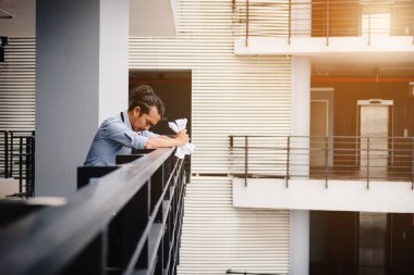 Balkon ofis Oda buruşuk kağıt üzerinde duran işadamı.