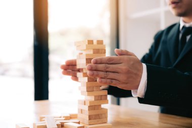 Eller işadamı blok ahşap risk kavramı ile tabloda korumak.