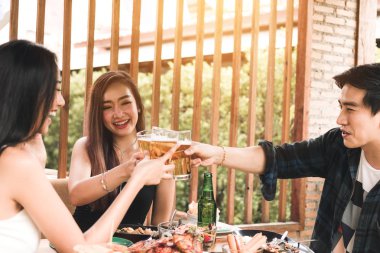 Teeneger Asya arkadaş bir restoranda akşam yemeği tadını çıkarırken bardakları tokuşturup.