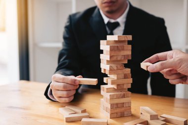 İki iş adamları yıkılmaya ahşap blok tutmak için yardım.