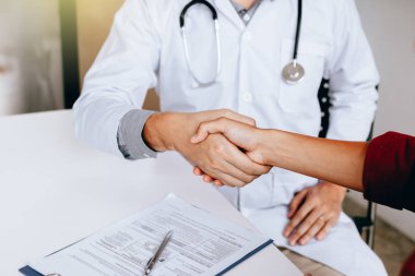 Klinikte hasta elini sıkarken doktor.