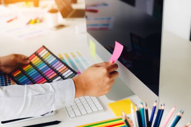 Grafik tasarımcı erkekler el bilgisayar ekranında Etiket Yapıştırma.