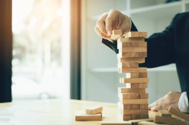 Proje yönetimi stratejisi planlama ile ahşap blok yığınları oyun oynarken işadamı el.