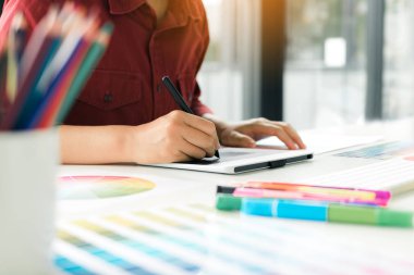 Dijital grafik tablet kullanarak ve modern ev ofis kalemiyle çizim masası üzerinde serbest yaratıcı tasarımcı.