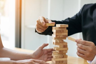 İki iş adamları yıkılmaya ahşap blok tutmak için yardım.