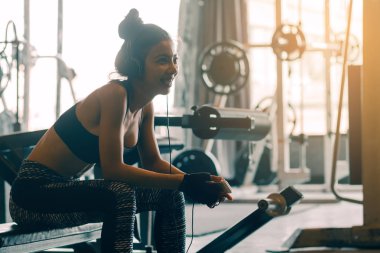 Asyalı kadın rahatlatıcı sağlıklı ve egzersiz dinle müzik spor salonunda egzersiz sonra ile.