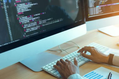 Asyalı adam kod programı geliştiricisi bilgisayar geliştirme web tasarım yazılımı ofiste masa üzerinde çalışıyor.