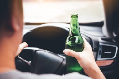 Asya erkekler bir şişe bira tutup sürüş sırasında içme trafik kuralları ihlal.