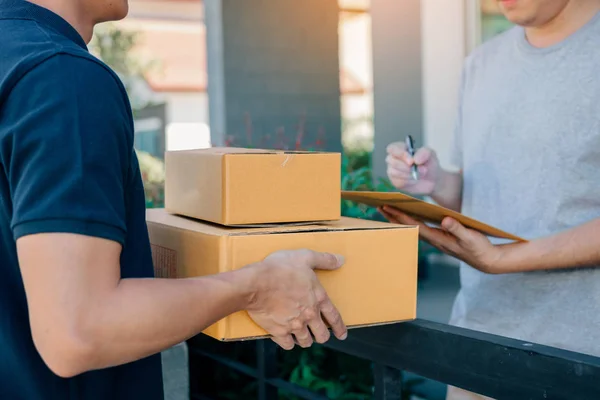 Levering jongeman die par en die permanent bij de deur van huis — Stockfoto