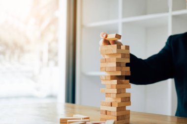 El plannin ile ahşap blok yığınları oyun oynarken işadamı