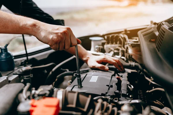 O mecânico do carro usa uma chave inglesa para abrir a caixa do motor do carro . — Fotografia de Stock