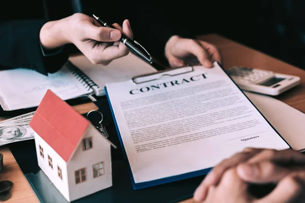 Home-agenten zijn pennen verzendt naar klanten van een contract te tekenen — Stockfoto