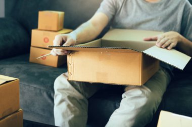 Asya girişimci genç bir karton kutu sırayla açıyor 