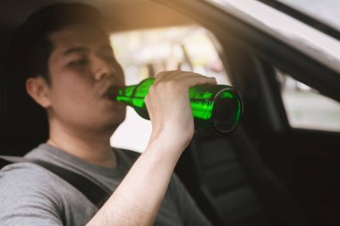 Asya'ya ait adam sarhoş alkolle yolda sürüş sırasında bira içmek.