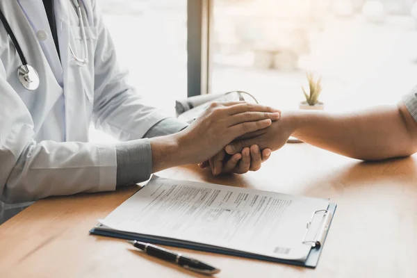 El médico toma de la mano y deja consejeros reconfortantes para el paciente. — Foto de Stock