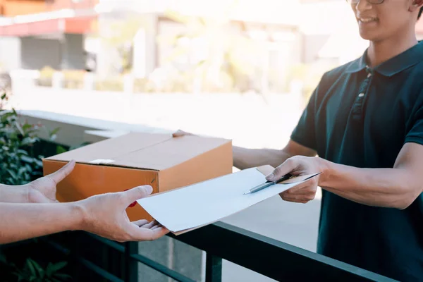 Joven asiático hombre sonriendo mientras la entrega de una caja de cartón a la —  Fotos de Stock