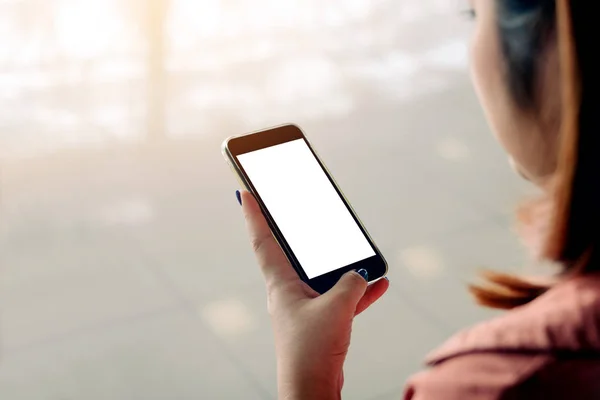 Азиатская женщина, использующая смартфон с белым экраном и прикасающаяся к нему — стоковое фото