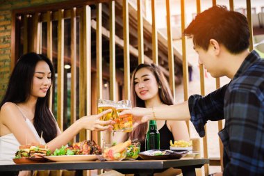 Teeneger Asya arkadaşlar bir evenin tadını çıkarırken bardakları tokuşturup