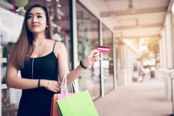 Stäng upp hand kvinnor innehar kreditkort och shoppingkassar på — Stockfoto