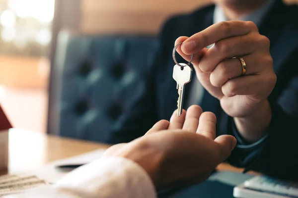 Close up hand of home agents are handing out keys to new home bu