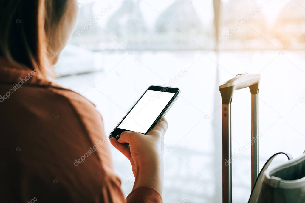 Asian tourist woman hands holding and using smartphone with blan