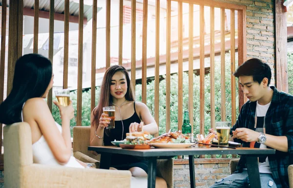 Asya gençler eğleniyor arıyla tezahürat ile içme — Stok fotoğraf