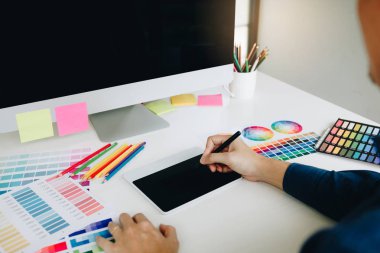 Serbest yaratıcı tasarımcı dijital grafik kullanarak masanın üzerinde çalışma