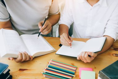 Kütüphanede sınava hazırlanan kitaplarla Asyalı öğrenci eğitimi.