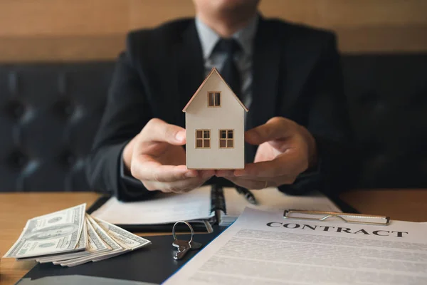 Personal de ventas de bienes raíces dan el hogar artificial a los clientes . — Foto de Stock