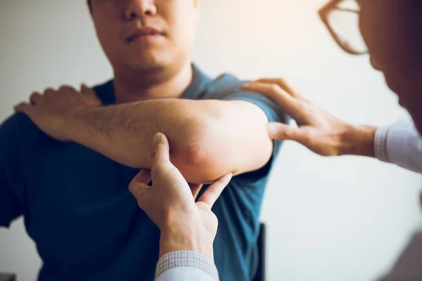 물리 치료사가 클리닉에서 환자의 팔꿈치를 검사하고 있습니다. — 스톡 사진